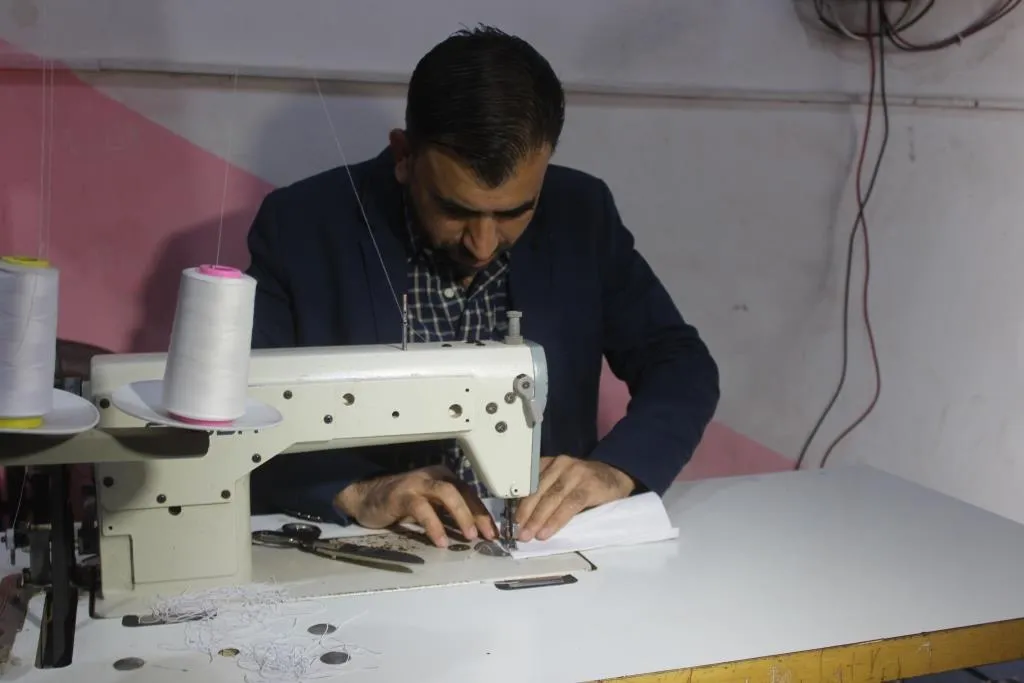 خياط ألبسة نسائية يتحول إلى خياطة الكمامات في ظل نقصها