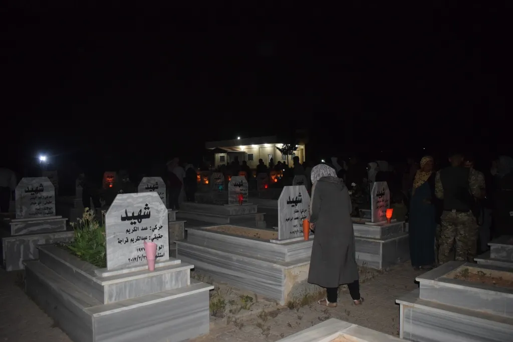 بمناسبة عيد الشهداء...أهالي منبج ينيرون أضرحة شهدائهم بالشّموع
