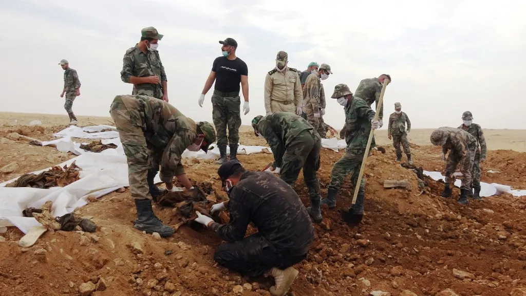 57 remains of "93rd Brigade" members exhumed from two cemeteries in Ain Issa countryside