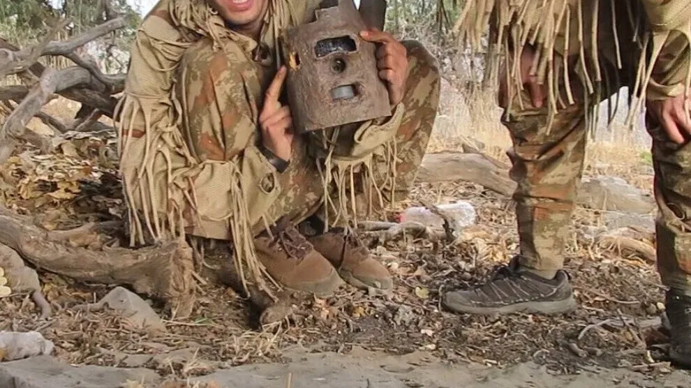 Guerrilla fighters find a camera of the Turkish occupation army mounted inside a tree trunk
