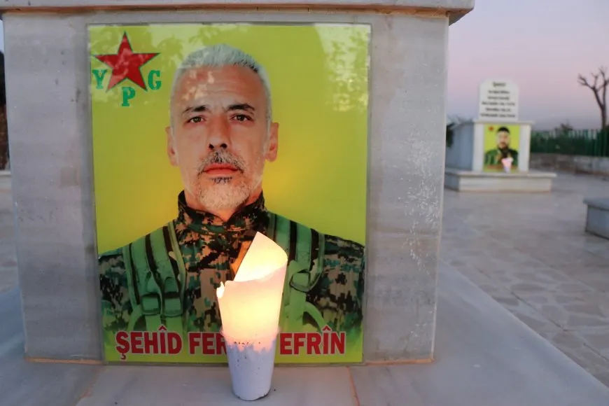 La gente enciende velas ante las tumbas de los mártires