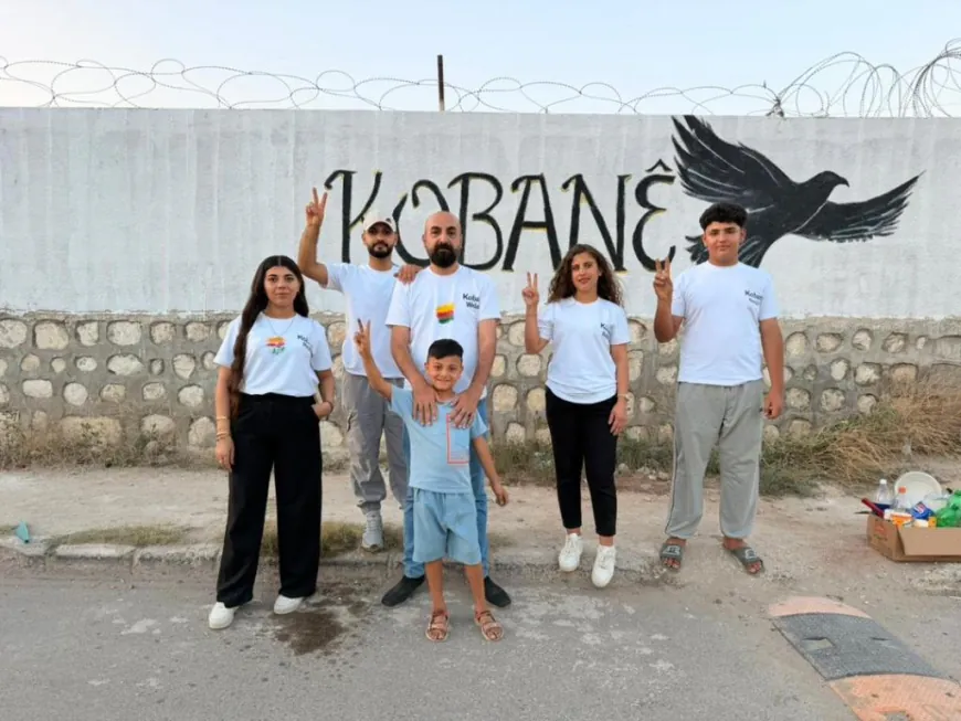Jóvenes de Kobanê pintan el nombre de la ciudad en un mural artístico