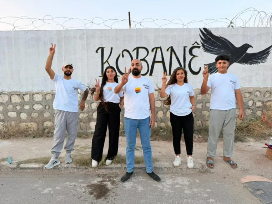 Jóvenes de Kobanê pintan el nombre de la ciudad en un mural artístico