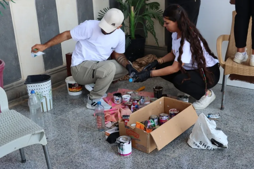 Jóvenes de Kobanê pintan el nombre de la ciudad en un mural artístico