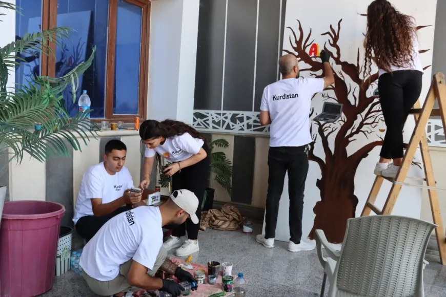 Jóvenes de Kobanê pintan el nombre de la ciudad en un mural artístico