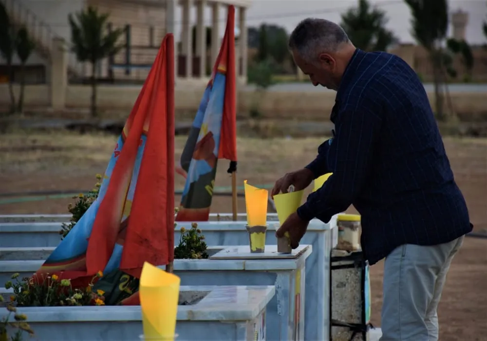 ​​​​​​​Bi boneya Roja Şehîdan mûm li ser gorên şehîdan hatin vêxistin