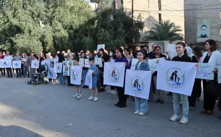 Koçberên Serêkaniyê li ber avahiya NYʹyê ya Qamişloyê çalakiyek li dar xist