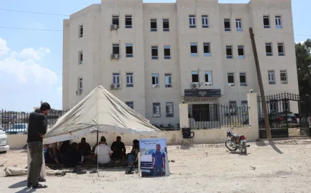 Malbata girtiyekî li ber avahiya Rêveberiya Kobanê banga naskirina çarenûsa kurê xwe dike