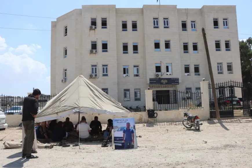Malbata girtiyekî li ber avahiya Rêveberiya Kobanê banga naskirina çarenûsa kurê xwe dike